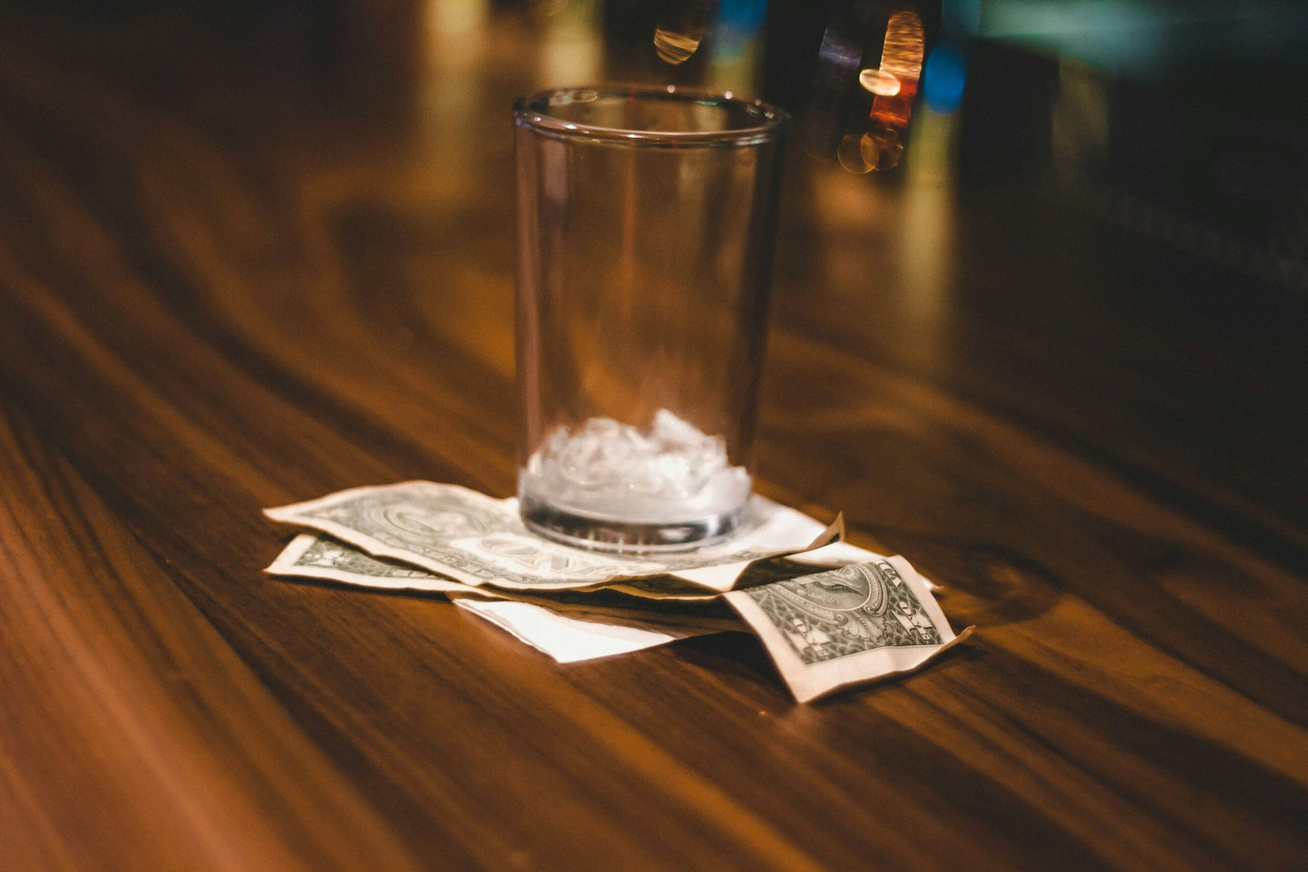 Verre posé sur des billets, illustration du budget boissons